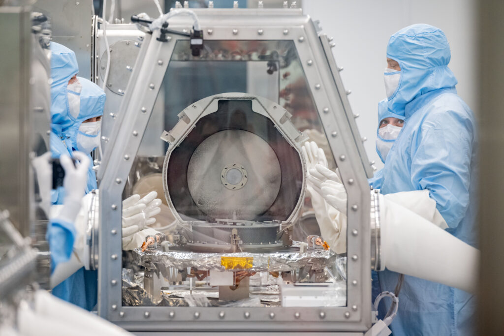 NASA curation team members along with Lockheed Martin recovery specialists look on after the successful removal of the sample return canister lid. Credit: NASA/Robert Markowitz